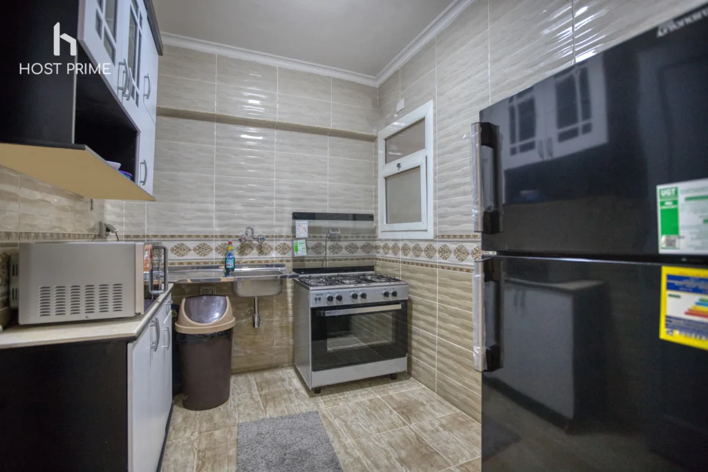 A spacious 2 bedroom living room with a sofa, a coffee table, and a TV in a Host Prime serviced apartment in New Cairo