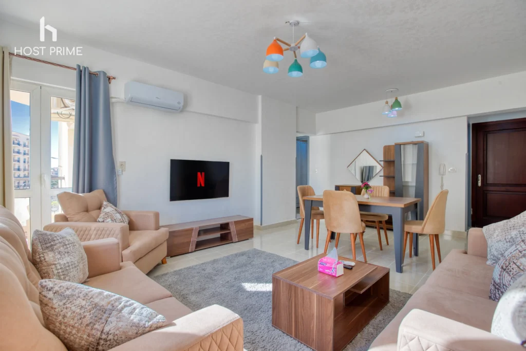 A cozy bedroom with a queen-sized bed, a nightstand, and a lamp in a Host Prime accommodation in New Cairo