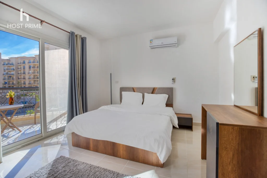 A spacious living room with a sofa, a coffee table, and a TV in a Host Prime serviced apartment in New Cairo