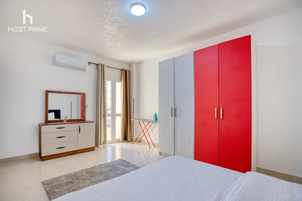 A spacious living room with a sofa, a coffee table, and a TV in a Host Prime serviced apartment in New Cairo