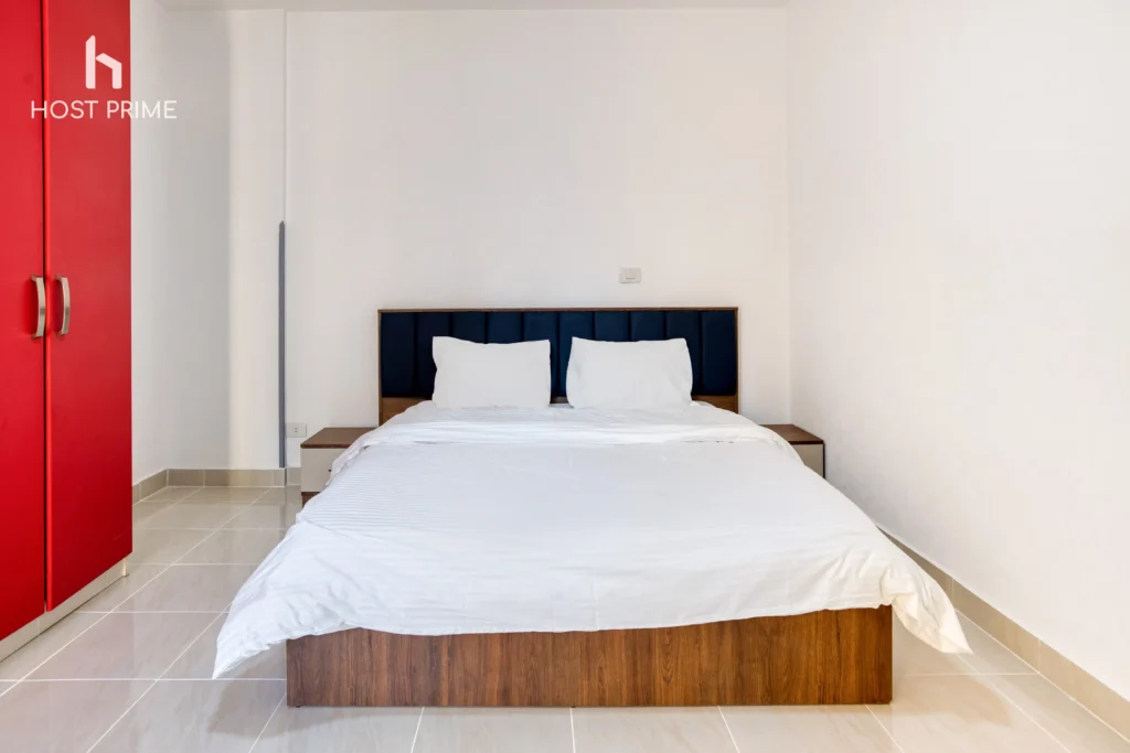 A spacious 2 bedroom living room with a sofa, a coffee table, and a TV in a Host Prime serviced apartment in New Cairo