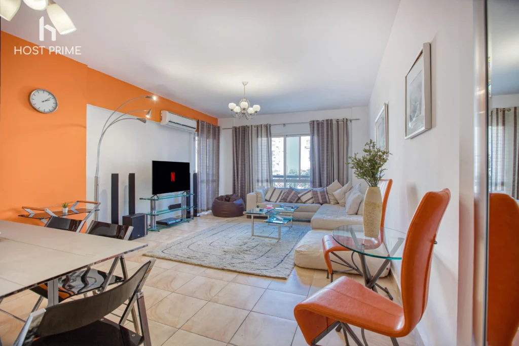 A comfortable living room with a sofa, a coffee table, and a TV in a Host Prime serviced apartment in Cairo