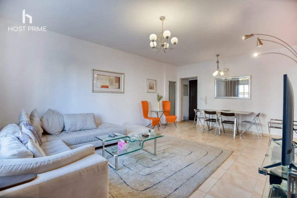 A stylish kitchen with a fridge, a stove, and a microwave in a comfy 2-bedroom apartment in Cairo