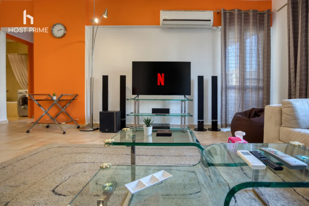 A balcony with a view of the city and a table with chairs in a comfy 2-bedroom apartment in Cairo