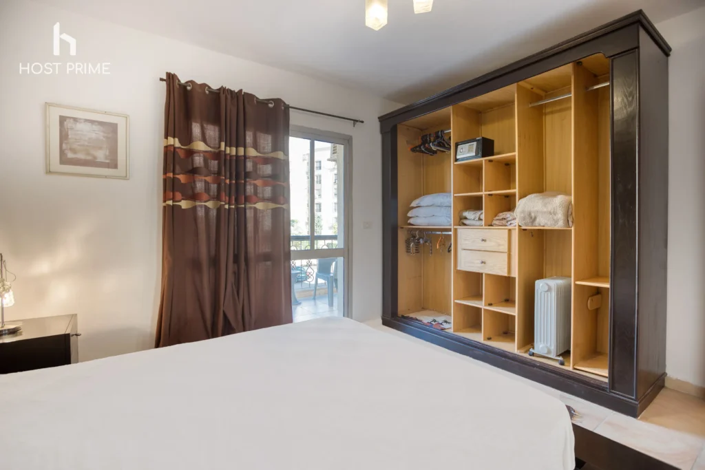 A cozy bedroom with a queen-sized bed, a nightstand, and a lamp in a Host Prime accommodation in Cairo