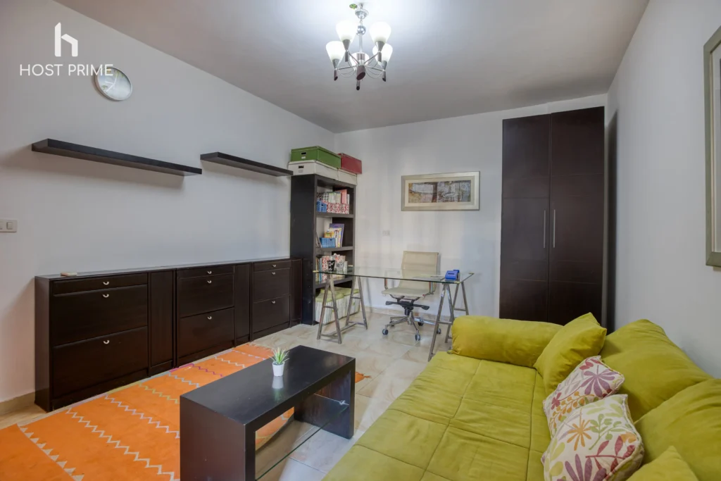 A cozy bedroom with a queen-sized bed, a nightstand, and a lamp in a Host Prime accommodation in Cairo