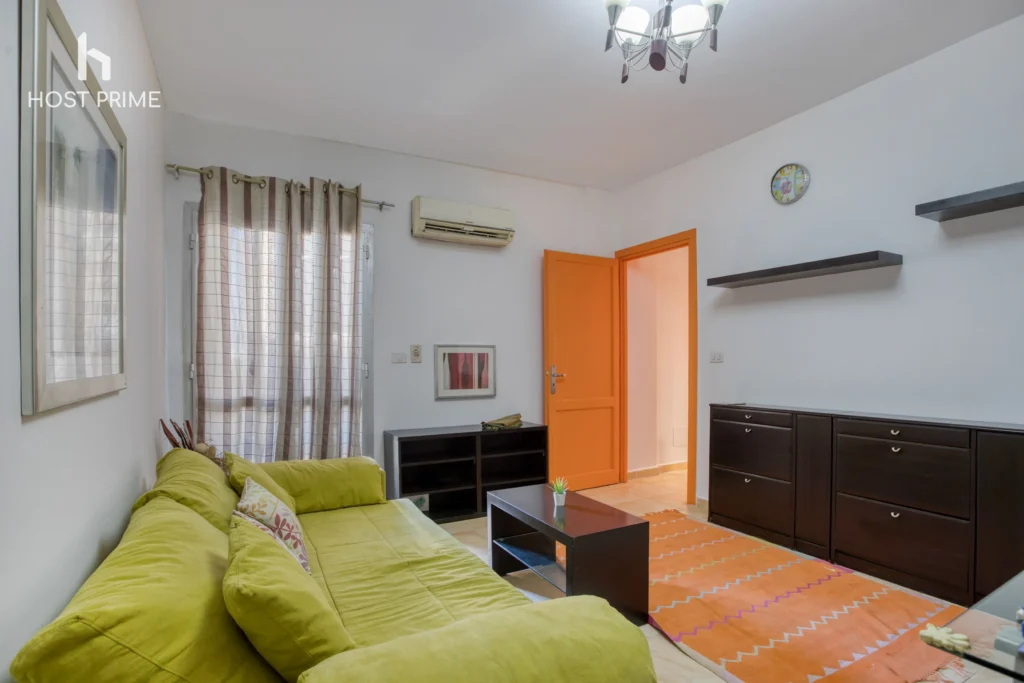 A stylish kitchen with a fridge, a stove, and a microwave in a comfy 2-bedroom apartment in Cairo