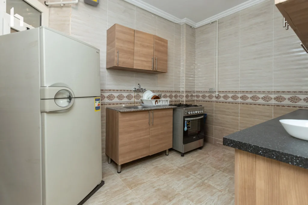 Modern kitchen with stainless steel appliances in your Al Rehab City serviced apartment.