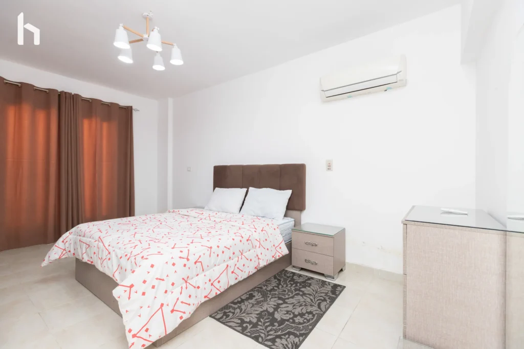 Inviting guest bedroom in spacious Al Rehab City serviced apartment.